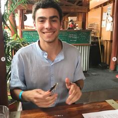 a man sitting at a table with a cell phone in his hand