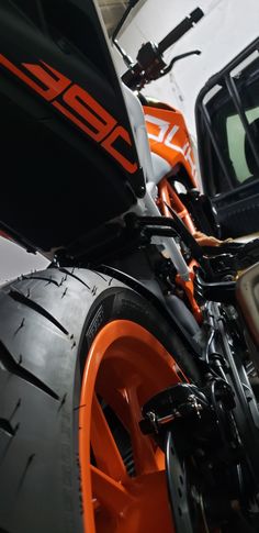 an orange and black motorcycle parked in a garage