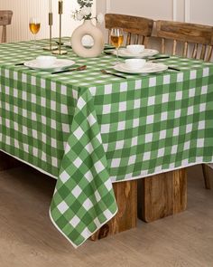 a green and white checkered table cloth on a dining room table with wine glasses