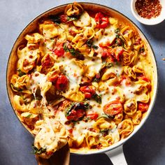 a skillet filled with pasta and vegetables