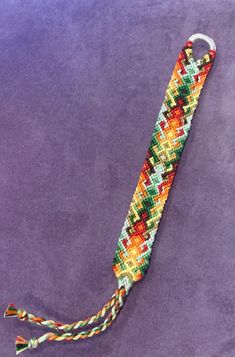 a tie that is laying on top of a purple surface with a white string attached to it