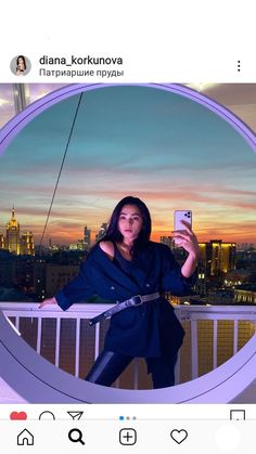 a woman taking a selfie with her cell phone in front of a cityscape