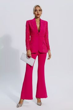 a woman in a bright pink suit and matching clutch is posing for the camera with her hand on her hip