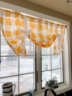 a kitchen window with yellow and white checkered curtains