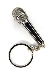 a microphone keychain is shown on a white surface with a black ring around it