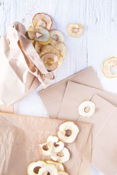 some doughnuts are sitting on top of brown envelopes and paper bags next to them