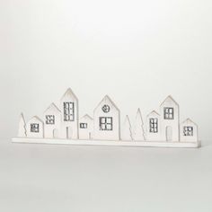 a group of small white houses sitting on top of a table next to each other