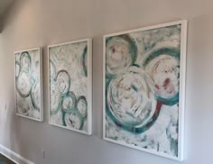 three paintings are hanging on the wall next to each other