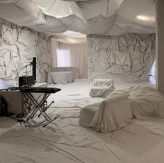 a room that has some white sheets on the floor