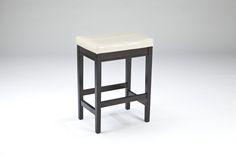 a black leather stool sitting on top of a white floor