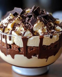 a dessert dish with chocolate, cream and whipped cream in it on a wooden table