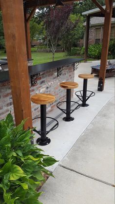 three wooden stools sitting on top of a sidewalk