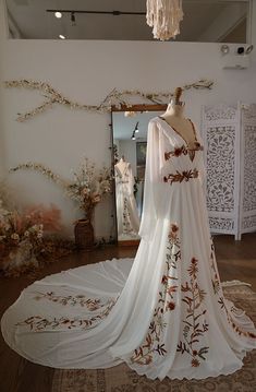 a dress on display in a room with a mirror and chandelier hanging from the ceiling