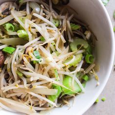 a white bowl filled with noodles and vegetables