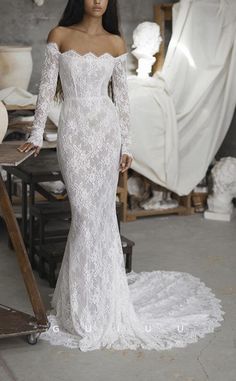 a woman in a white wedding dress posing for the camera