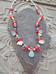 "Colorful gemstone necklace in rich vibrant colors that will remind you of sea, beach an summer. This necklace will look great with white ,black, blue and anything in-between. It is had strung with chalcedony brioletts, fresh water pearls, coral and sterling silver elements. This is a real treat for a lady who likes one of a kind and not so typical pieces. The necklace is a choker style and measures 17\" Please see matching earrings https://www.etsy.com/listing/1557944640/blue-chalcedony-peals-a Natural Stone Strand Jewelry As Gift, Strand Jewelry With Natural Stones As A Gift, Gift Jewelry With Natural Stones In Strand Shape, Unique Beach Jewelry Gemstone Beads, Ocean-inspired Beaded Necklaces With Natural Stones As Gift, Unique Beach Jewelry With Gemstone Beads, Unique Gemstone Jewelry For The Beach, Handmade Ocean Color Necklaces For Jewelry Making, Ocean-inspired Colorful Bead Necklaces For Gifts