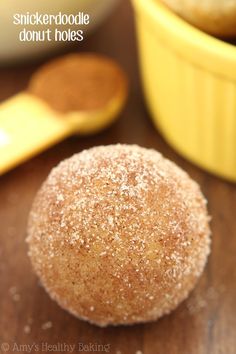 a sugary pastry sitting on top of a wooden table next to two yellow bowls