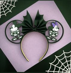 a mickey mouse ears headband on top of a purple and black background with spider web