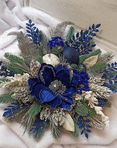 a blue and white flower arrangement sitting on top of a blanket