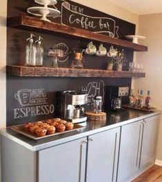 a coffee bar with chalkboard on the wall and shelves above it that have donuts