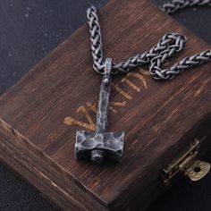 an iron cross on top of a wooden box with chains hanging from it's sides