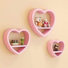 three pink heart shaped shelves with stuffed animals on them and one has a teddy bear