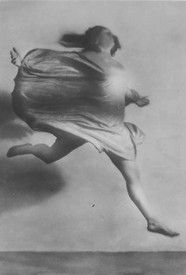 a black and white photo of a woman flying through the air