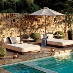 an outdoor lounge area next to a swimming pool