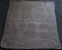 a white crocheted blanket sitting on top of a table