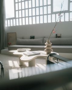 a living room filled with furniture and a vase sitting on top of a coffee table