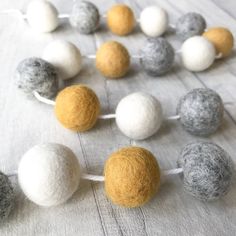 felt balls are arranged in the shape of a circle on a white tablecloth with string