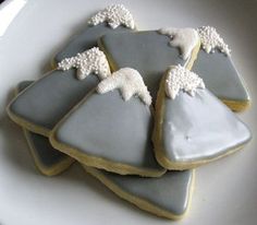 four decorated cookies sitting on top of a white plate