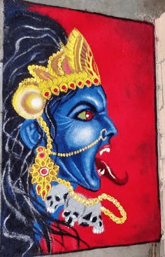 a painting on the side of a building that has a blue face and gold headdress