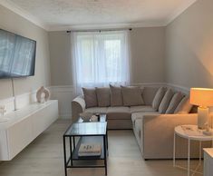 a living room filled with furniture and a flat screen tv mounted to the side of a wall