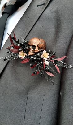 a man in a suit with a fake skull on his lapel flower pin attached to it