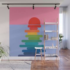 a rainbow wall mural in a living room with a chair and bookshelf next to it