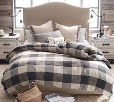 the bed is made with plaid sheets and pillows