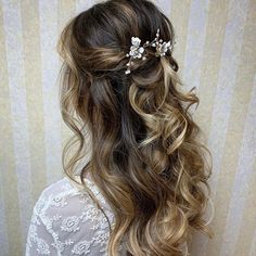 the back of a woman's head with long hair and flowers in her hair