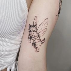 a woman with a tattoo on her arm has a cat and bee design on it