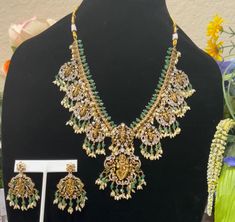 Enhance your beauty with this radiant gold-plated necklace, featuring a delicate design adorned with stunning green,ruby and white cubic zirconia stones. Complemented by matching earrings, this set exudes elegance and grace, making it perfect for any special occasion. A Dasavatharam necklace is a piece of jewelry featuring the ten principal avatars of the Hindu god Vishnu. Each avatar represents a different incarnation of Vishnu, appearing on Earth to restore cosmic order and righteousness. The Green Temple Jewelry Necklace For Anniversary, Gold Emerald Jewelry Sets For Celebration, Green Temple Jewelry Set For Anniversary, Gold Jeweled Emerald Necklace Gift, Festive Gold Emerald Jewelry Sets, Dashavataram Necklace, Dasavatharam Necklace, South Indian Bride Jewellery, Guttapusalu Haram