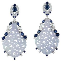 These stunning hand carved Jade earrings are crafted in 18-karat gold. It is set in 23.05 carats Jade, 4.96 carats blue sapphire and .90 carats of sparkling diamonds. FOLLOW MEGHNA JEWELS storefront to view the latest collection & exclusive pieces. Meghna Jewels is proudly rated as a Top Seller on 1stDibs with 5 star customer reviews. All items manufactured by us are handmade and can be customized or redesigned. Composition Size-54X24 MM Total Weight-14.84 Gold Weight(Gms)-9.058 Diamond Wt(Cts)-