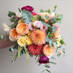 a person holding a bouquet of flowers in their hand