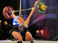 a woman lifting a barbell during a competition