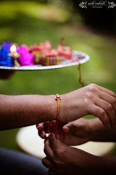 two people holding hands over a plate with cupcakes on it