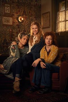 three women are sitting on a couch together