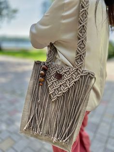 a woman carrying a purse with tassels on it