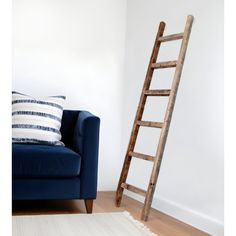 a living room with a blue couch and a wooden ladder leaning up against the wall