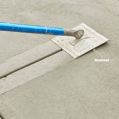 a blue and white baseball bat sitting on top of a cement field next to a patch of dirt