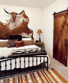 a bedroom with a cow skull head on the wall above the bed and rugs