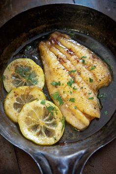 chicken with lemon slices and parsley in a skillet